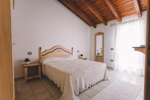Schlafzimmer mit einem Bett, einem Tisch und einem Fenster in der Unterkunft Sole d'Estate Agriresidence in Costa Rei