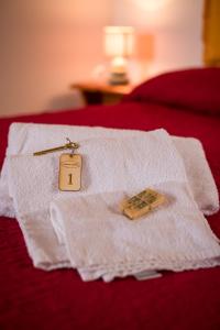 een witte handdoek met een prijskaartje op een bed bij Il Rifugio del Contadino Art & Nature in Bosco