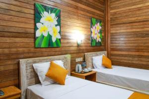 two beds in a room with wooden walls at D'Tegal House in Nusa Lembongan +26 photos