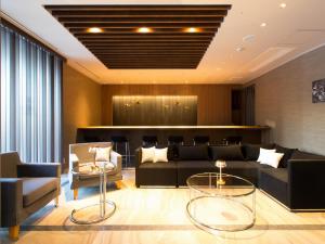 a lobby with a couch and chairs and a bar at Hotel Shiki Utsubo Park in Osaka