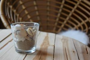 フリシンゲンにあるHotel Truidaの木製テーブルの上に貝殻を詰めたガラス