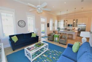 a living room with a blue couch and a kitchen at Coastal Home in South Padre Island