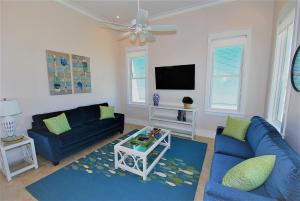 a living room with two blue couches and a tv at Coastal Home in South Padre Island