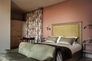 a bedroom with a large bed and a couch at The Xara Palace Relais & Chateaux in Mdina
