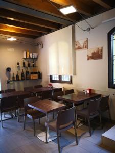 カスティリオーネ・デッレ・スティヴィエーレにあるLa Vecchia Tramviaの木製のテーブルと椅子、ワインボトルを用意したレストラン