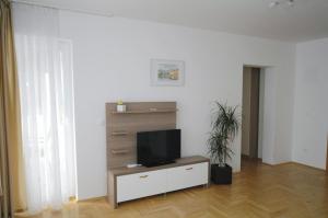 a living room with a flat screen tv on a cabinet at Haus Zora Ferienwohnung 7 in Mošćenice