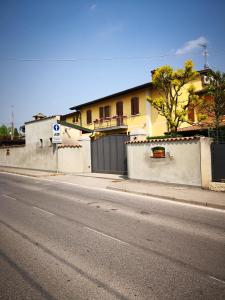 pusta ulica z domem i ogrodzeniem w obiekcie La Stazione Camere Caffè w mieście Castiglione delle Stiviere