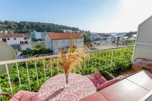een balkon met een tafel met een vaas erop bij Apartmani LuNa in Hvar