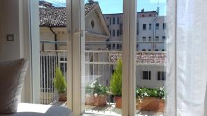 トレヴィーゾにあるL'Attico di Piazza Vittoriaの窓付きの建物の景色を望む客室です。