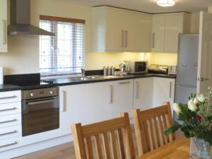 a kitchen with white cabinets and a table and chairs at Oxford Apartments 2 in Oxford