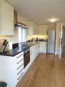 a kitchen with white cabinets and a wooden floor at Oxford Apartments 2 in Oxford