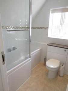a white bathroom with a shower and a toilet at Oxford Apartments 2 in Oxford