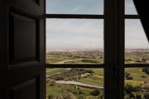 an open window with a view of a road at The Xara Palace Relais & Chateaux in Mdina