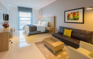 a living room with a bed and a couch at Sky Collection Lifestyle Hotel & Suites Barranquilla in Barranquilla