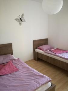 two beds in a room with pink and purple sheets at House Katarina in Ankaran