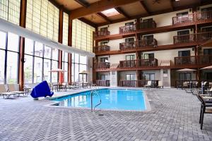 a large pool in a hotel with tables and chairs at Hotel 1620 Plymouth Harbor in Plymouth