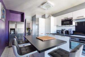 a kitchen with a black table and chairs at Appartement near Disney Parks in Chessy