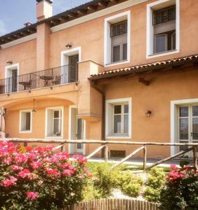 un bâtiment avec des fleurs roses devant lui dans l'établissement I Grappoli Divini, à Viarigi