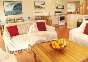 a living room with a bowl of fruit on a table at Point Village Accommodation - Laurie's House in Mossel Bay