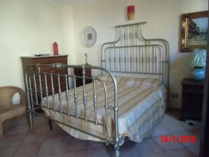 ポルティチェッロにあるHoliday home Santa Flavia 2のテーブル付きの部屋の金属製ベッド1台