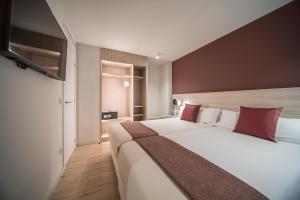 Rúm í herbergi á Hotel & Aparthotel Cosmos