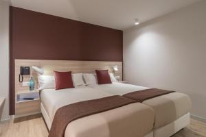 Rúm í herbergi á Hotel & Aparthotel Cosmos