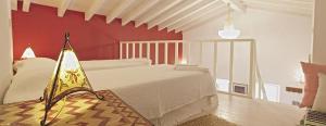 a bedroom with a white bed and a red wall at Monte da Xica - Somente Adultos in Zambujeira do Mar