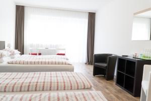 una habitación de hotel con 2 camas y una silla en Gasthof zur Post, en Hof bei Salzburg