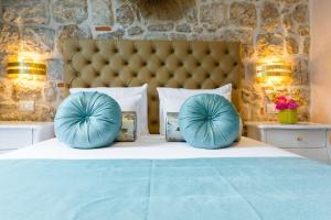 a bedroom with a bed with blue pillows on it at Dominus Rooms in Dubrovnik