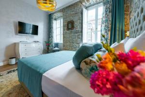 a bedroom with a large bed with flowers on it at Dominus Rooms in Dubrovnik