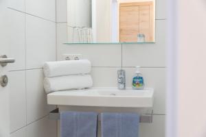 a bathroom with a sink and a mirror and towels at Gasthof zur Post in Hof bei Salzburg