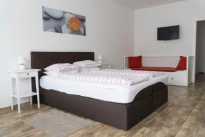1 dormitorio con 1 cama grande con sábanas rojas y blancas en Gasthof zur Post, en Hof bei Salzburg