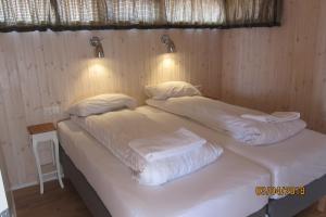 two beds in a room with white sheets and pillows at Reynivellir II in Gerdi