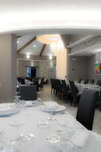 een grote eetkamer met witte tafels en stoelen bij Hotel Duca Di Calabria in Serra San Bruno