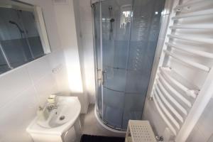a white bathroom with a shower and a sink at Johnny House in Suwałki +25 photos