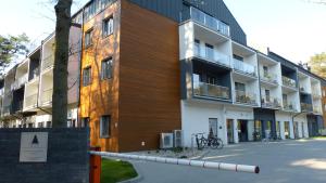 ein Apartmenthaus mit einem Zaun davor in der Unterkunft Dwie Sosny i Świerk 2 in Ustronie Morskie