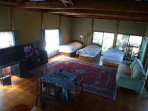 ein Wohnzimmer mit 2 Betten und einem Tisch in der Unterkunft Wakihonjin in Kikugawa