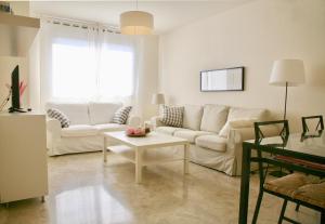 - un salon avec un canapé blanc et une table dans l'établissement Apartamento Ollerías, 31, à Cordoue