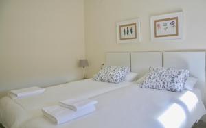 - un lit blanc avec 2 serviettes dans l'établissement Apartamento Ollerías, 31, à Cordoue