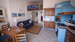 een keuken en een woonkamer met een bank en een tafel bij Vicino al mare nel cuore di Santa Teresa Gallura in Santa Teresa Gallura