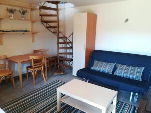 a living room with a blue couch and a table at Amanitis Stone House in Kipoi