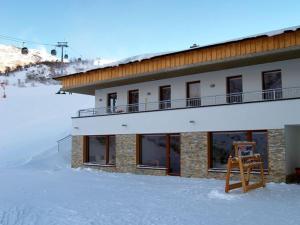 un edificio en la nieve con un cartel delante en Hotel Garni Birkhahn, en Galtür