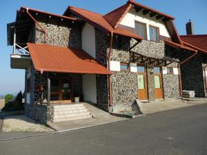 a building with an orange roof on a street at Penzión Vínny Dom in Streda nad Bodrogom