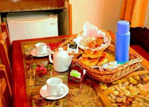 una mesa con tazas y una cesta de bollería en Lahuen-co Paraje de Mar en Valeria del Mar