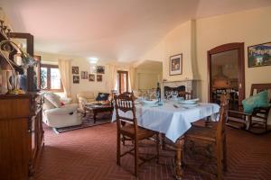 een woonkamer met een tafel en stoelen bij Villa Corrasi Oliena Luxury in Oliena +45 foto's