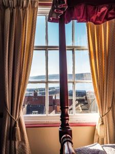 a bed in front of a window with a view at Tall Storeys in Scarborough