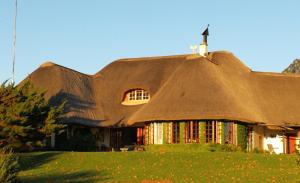 a thatched building with a cross on top of it at Little Milton in Nottingham Road