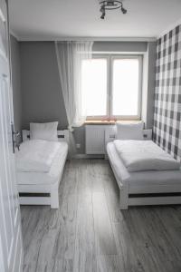 グダニスクにあるPokoje Kartuskaのベッドルーム1室(ベッド2台、窓付)