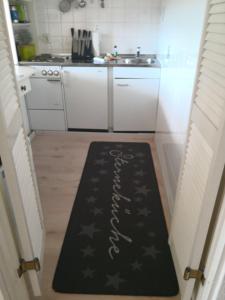 una cocina con alfombra negra en el suelo en Sylter Ferienwohnungen, en Westerland