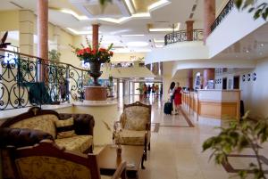 a lobby with two chairs and people walking in a mall at Duni Belleville - All Inclusive in Sozopol